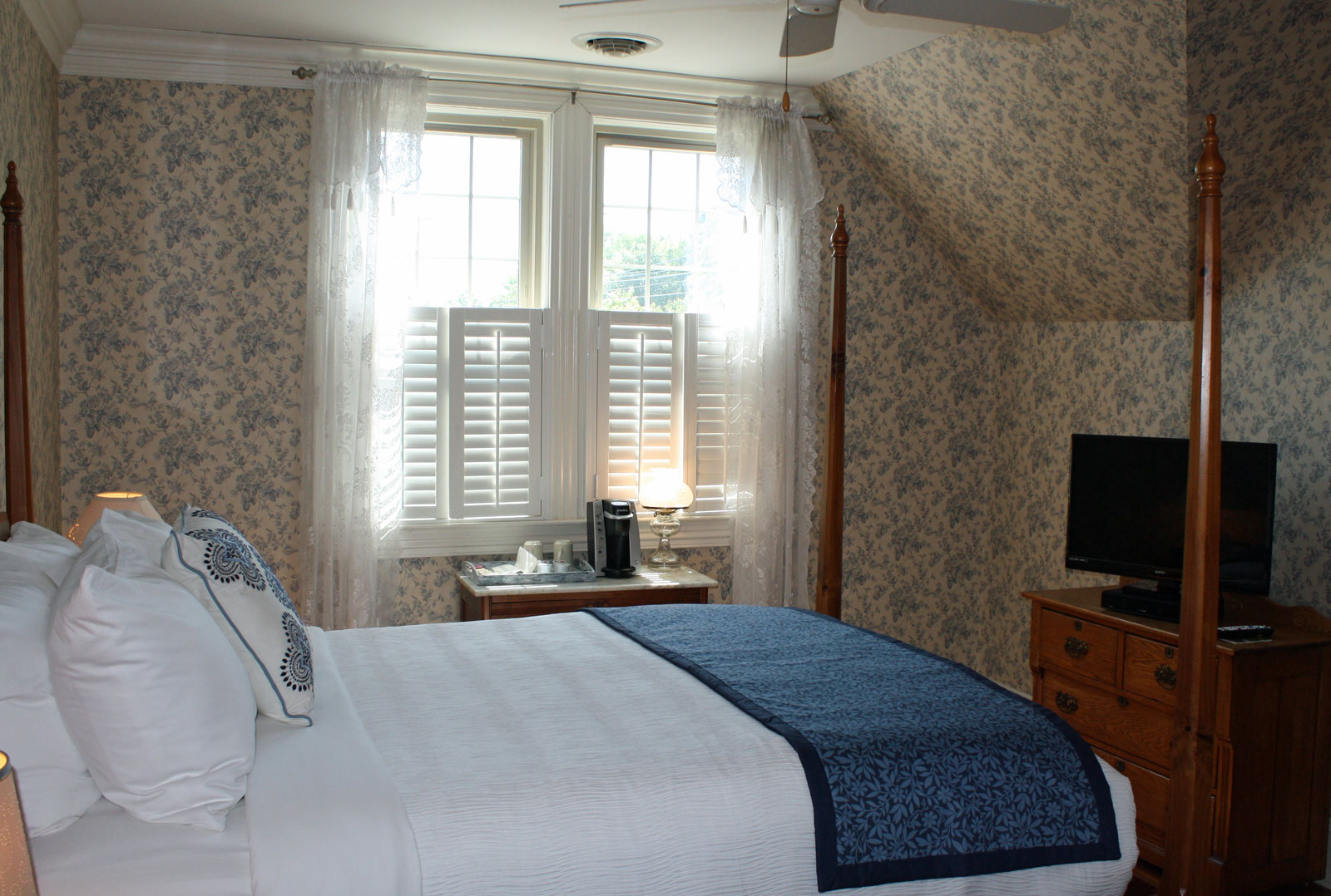 Bed, dresser with television, and window
